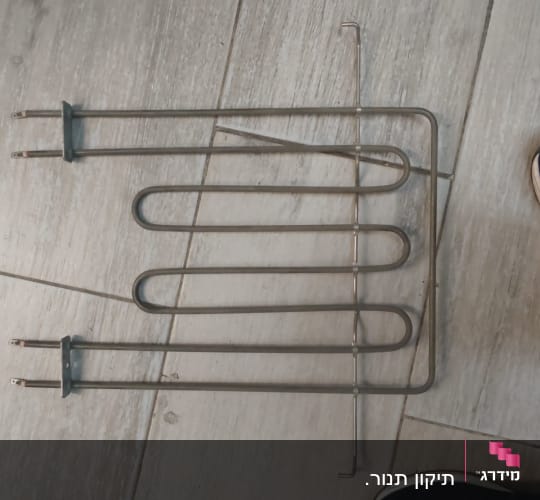 גוף חימום מתכתי על רצפת עץ